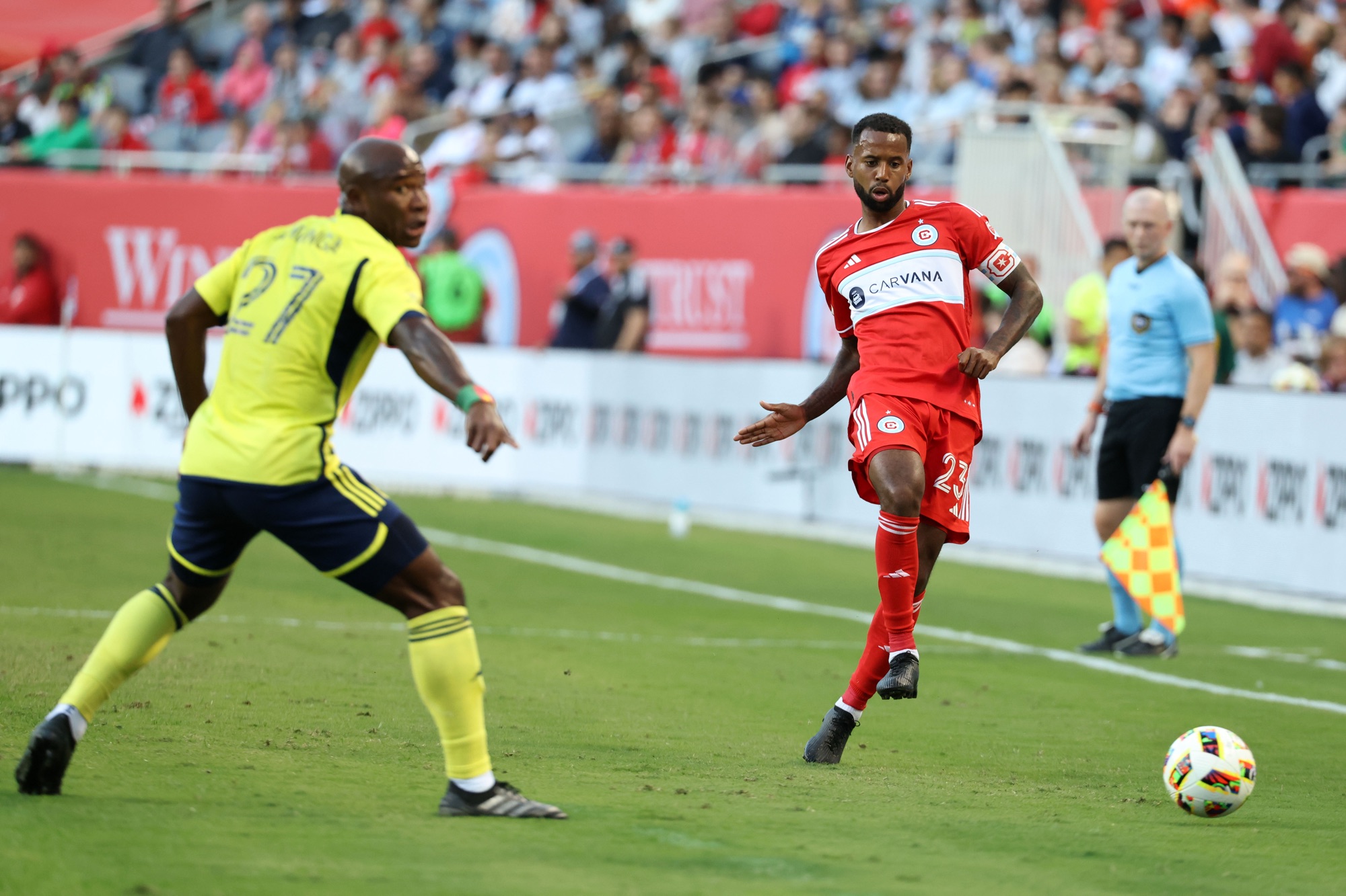 Oct 19, 2024; Chicago, Illinois, USA; Chicago Fire midfielder Kellyn Acosta (23) passes the ball past Nashville SC midfielder Brian Anunga (27) during the first half at Soldier Field. 