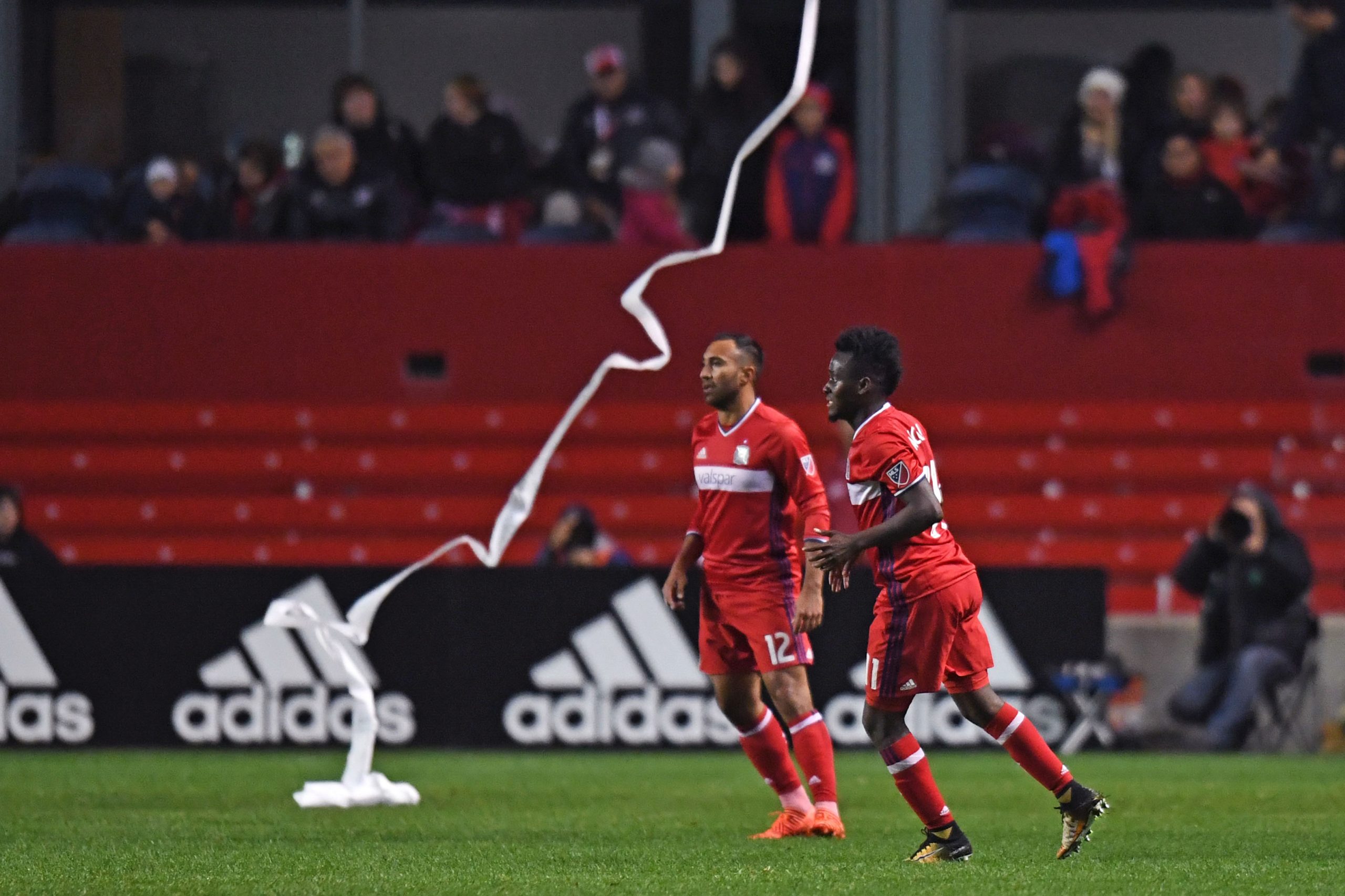 Oct 25, 2017; Chicago, IL, USA; Chicago Fire midfielder David Accam (11) and midfielder Arturo Alvarez (12) in action while a roll of toilet paper lands on the field during an Eastern Conference knockout round soccer game against the New York Red Bulls at Toyota Park. Red Bulls won 4-0. Mandatory Credit: Patrick Gorski-USA TODAY Sports