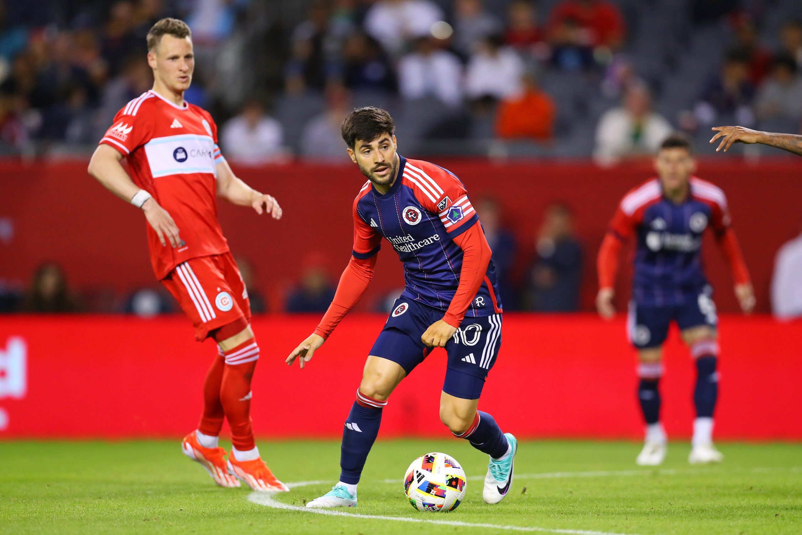 May 4, 2024; Chicago, Illinois, USA; New England Revolution midfielder Carles Gil (10) dribbles the ball against Chicago Fire FC during the second half at Soldier Field. 
