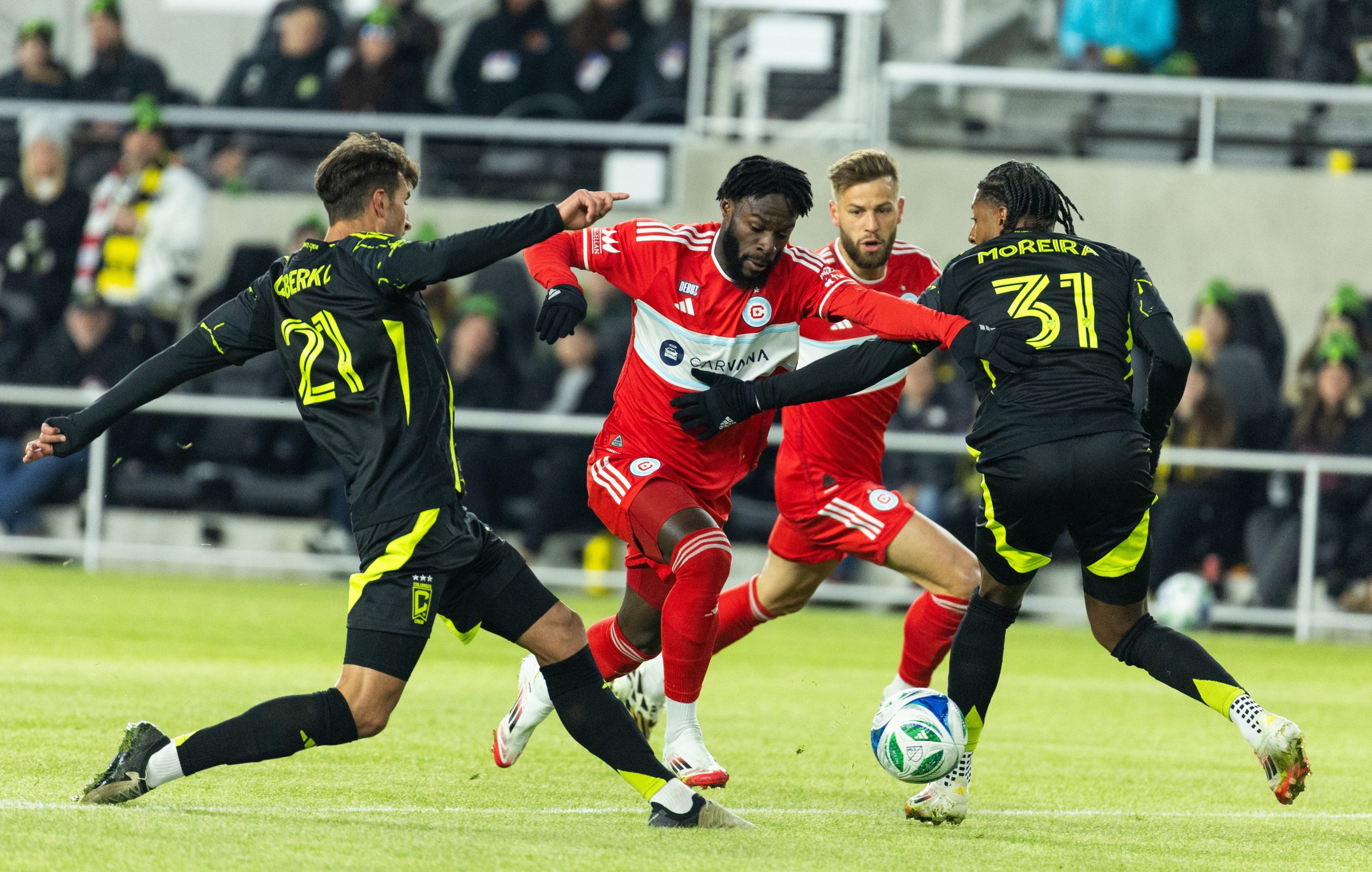 Feb 22, 2025; Columbus, Ohio, USA; Chicago Fire FC forward Georgios Κoutsias (19) dribbles the ball while Columbus Crew defender Yevhen Cheberko (21) and defender Steven Moreira (31) defend in the first half at Lower.com Field.