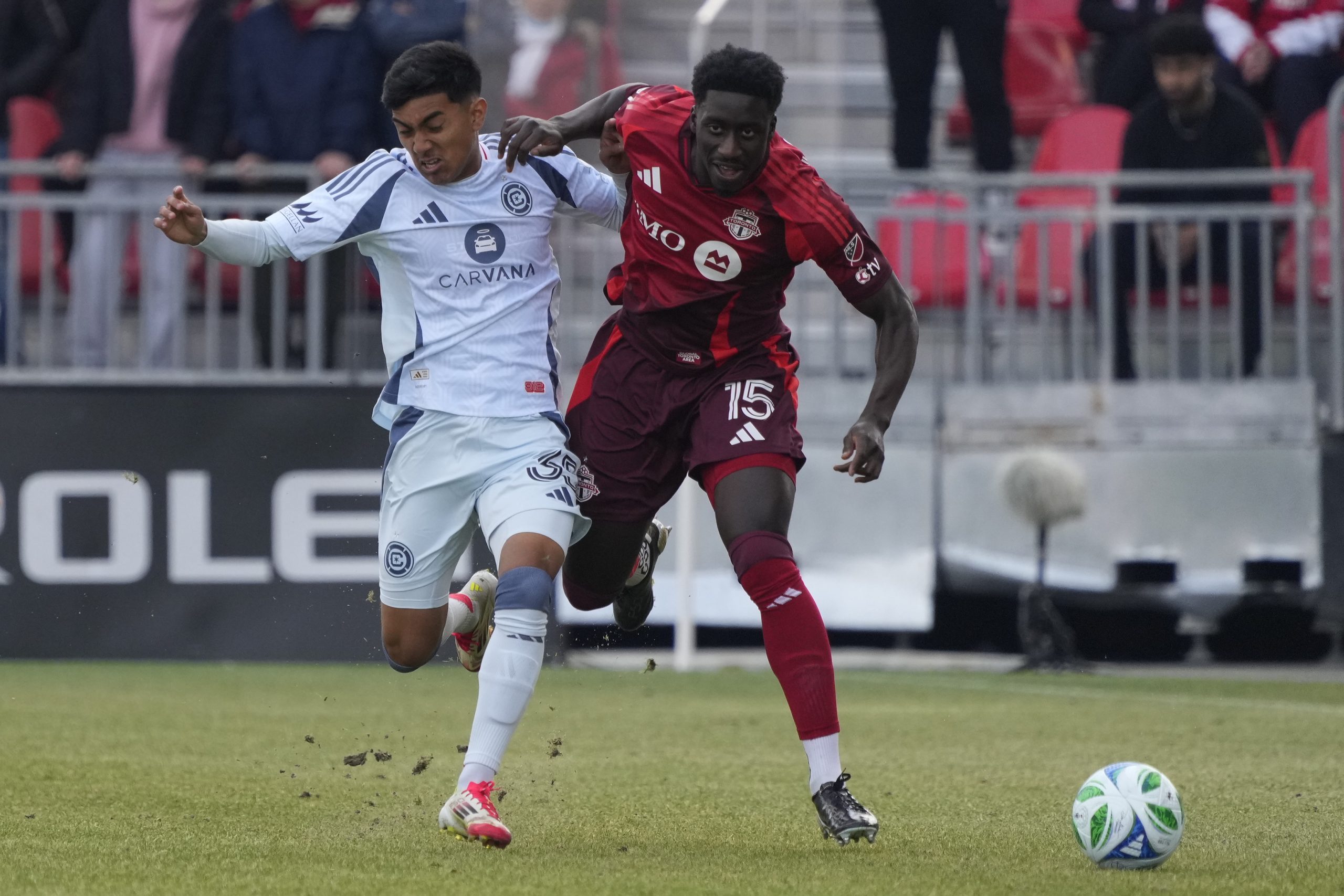 Mar 15, 2025; Toronto, Ontario, CAN; Toronto FC defender Nickseon Gomis (15) and Chicago Fire midfielder Sergio Oregel (35) battle for the ball during the first half at BMO Field. Mandatory Credit: John E. Sokolowski-Imagn Images