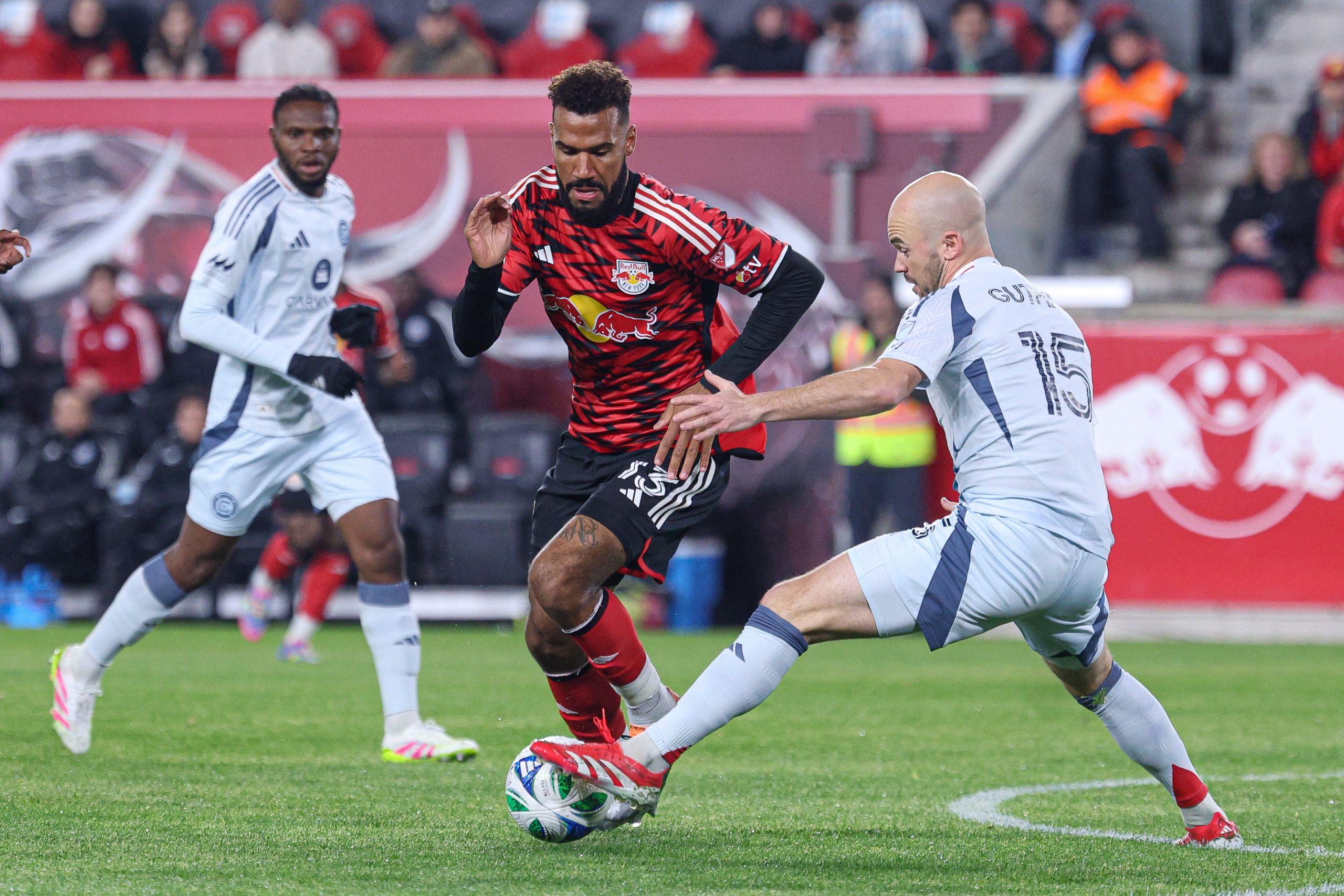 Apr 5, 2025; Harrison, New Jersey, USA; New York Red Bulls forward Eric Maxim Choupo-Moting (13) plays the ball against Chicago Fire FC defender Andrew Gutman (15) during the first half at Sports Illustrated Stadium. Mandatory Credit: Vincent Carchietta-Imagn Images