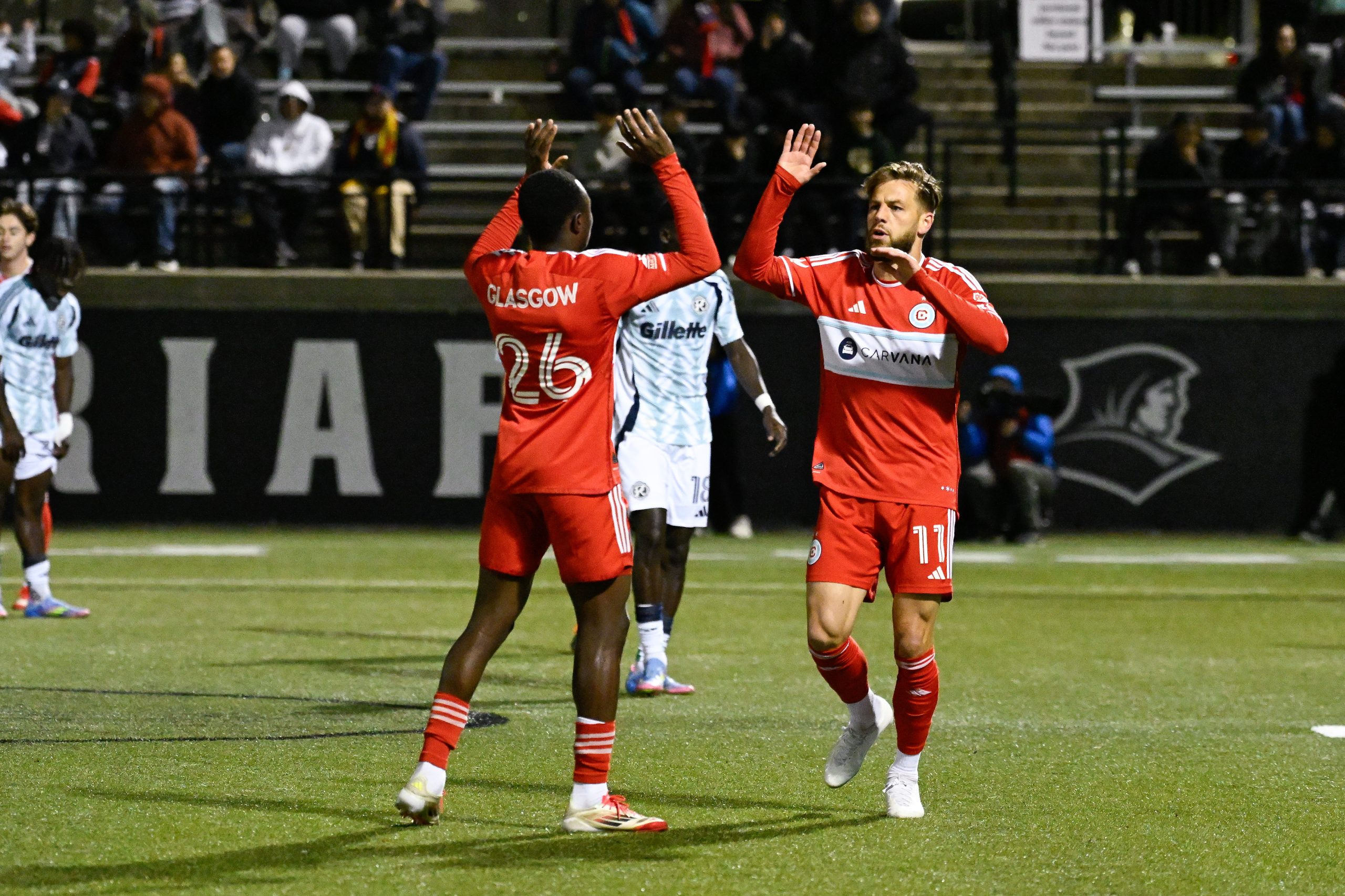 May 20, 2025; Providence, Rhode Island, USA; Chicago Fire forward Philip Zinckernagel (11) celebrates a goal against the New England Revolution with defender Omari Glasgow (26) during the second half at Chapey Field at Anderson Stadium.