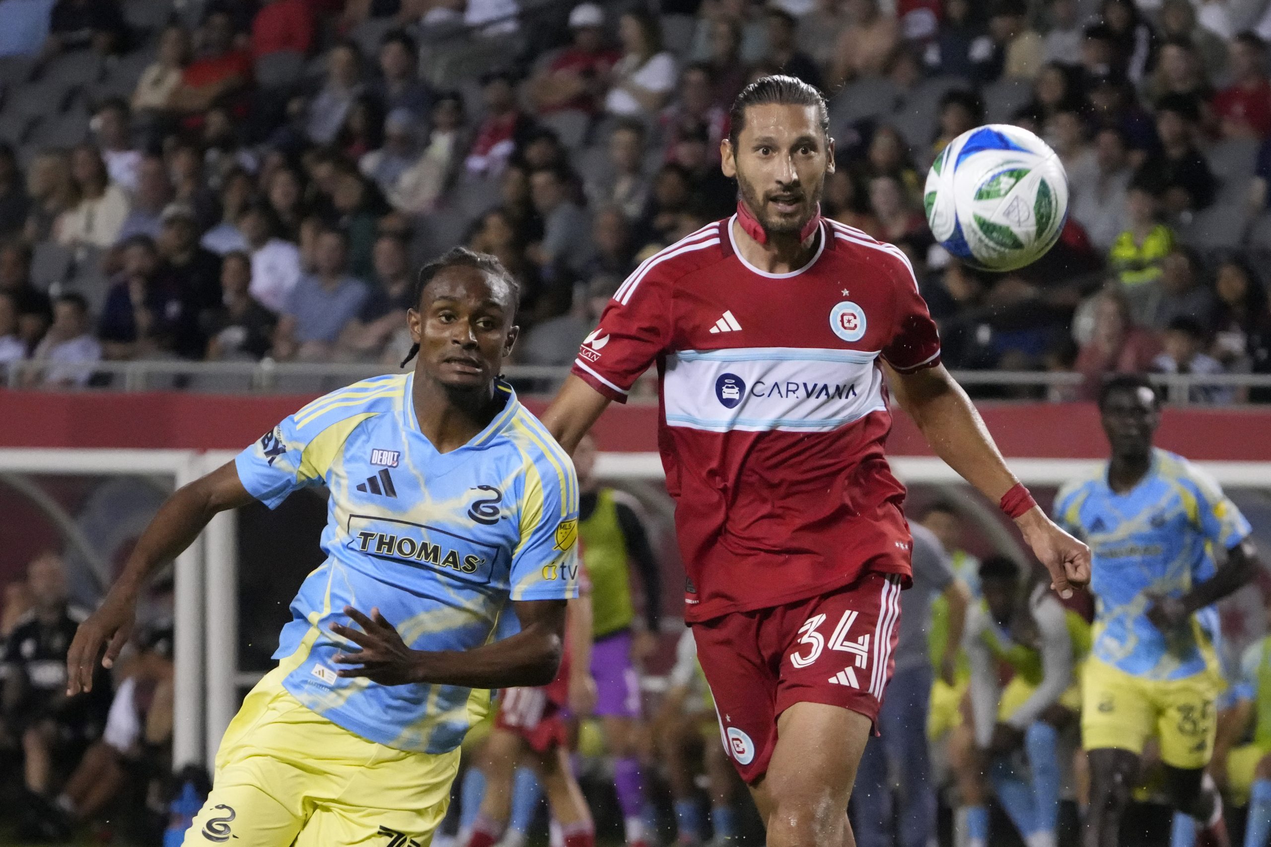 Jun 25, 2025; Chicago, Illinois, USA; Chicago Fire defender Omar Gonzlez (34) and Philadelphia Union forward Eddy Davis III (77) go for the ball during the second half at Soldier Field. Mandatory Credit: David Banks-Imagn Images