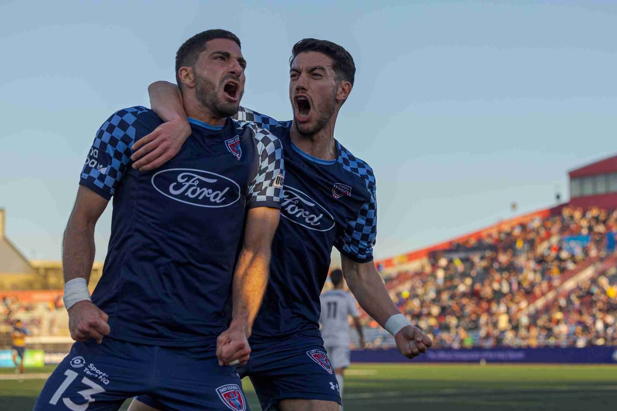 Indy Eleven players celebrate a goal during a soccer game.